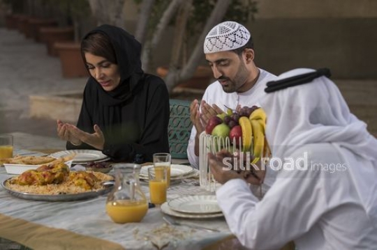 REPLACE - Middle Eastern family praying before they eat|-