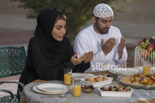 REPLACE - Arab man and woman praying before Iftar|-