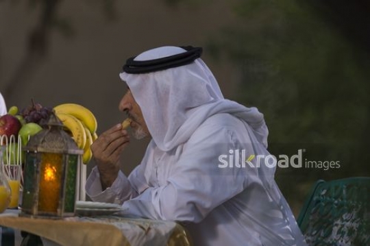 Arab grandfather having something to eat|-