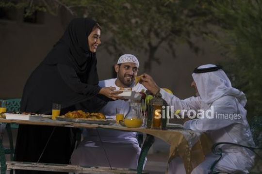 REPLACE - Arab woman offering food to the men on the table|-