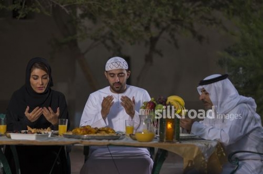 Arab family praying together before Iftar|-