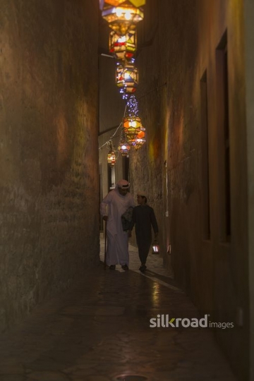 Middle Eastern father and son walking together carrying a Ramadan Lantern|-