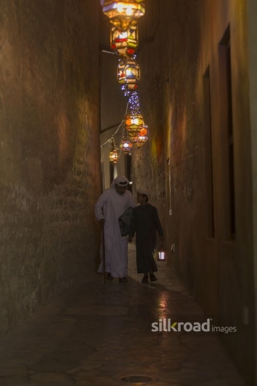 Arab father and son walking together carrying a Ramadan Lantern|-