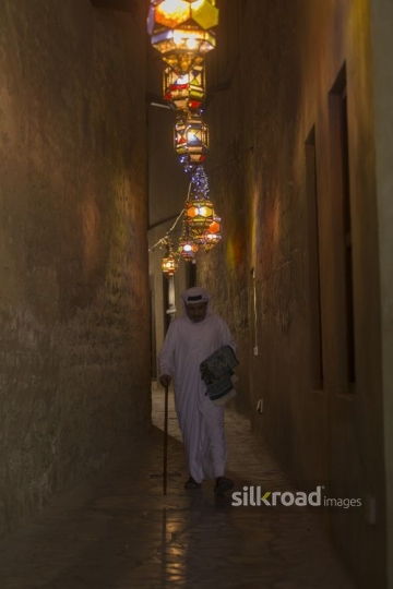 Arab man strolling through the alley decorated with Ramadan Lanterns-