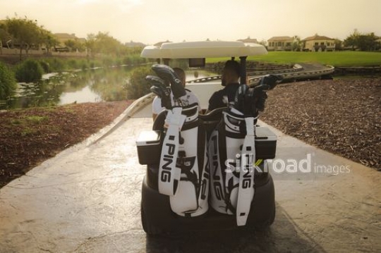 Men sitting on the Golf Cart together |-