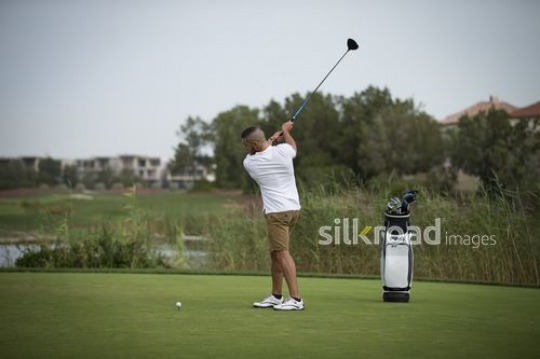 Arab man playing golf|-