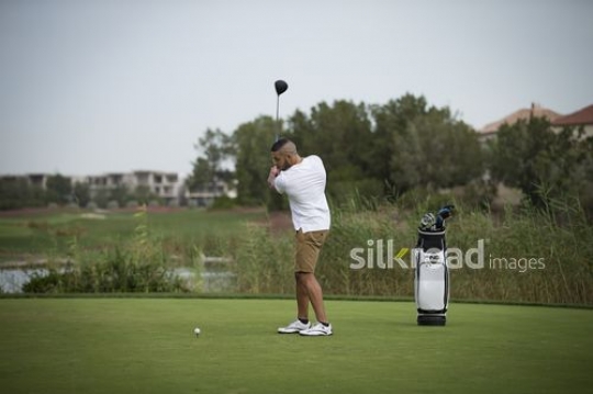Middle Eastern man playing golf|-