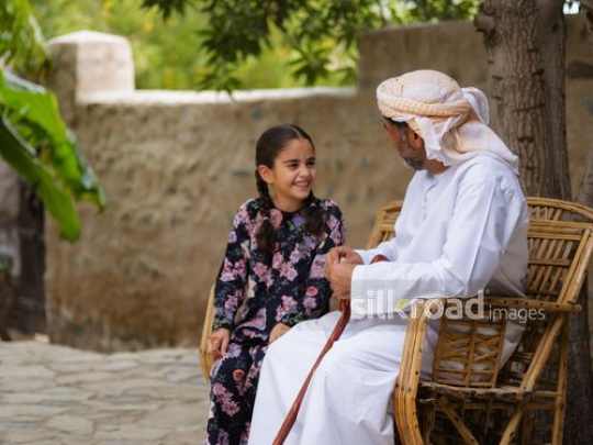 Girl enjoying grandfather storytelling|-