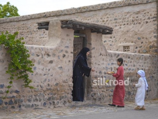 Woman receiving kids at the door|-