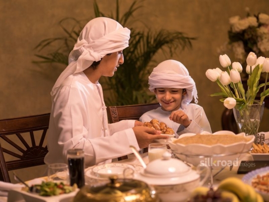 Brother serving Arabic sweets|-