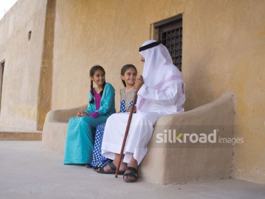Girls sitting with grandfather|-
