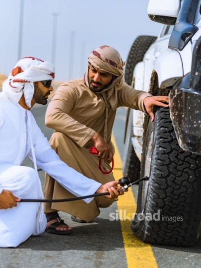 Friends fixing flat tire