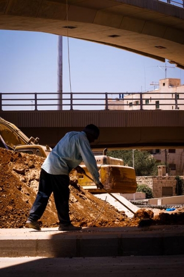 worker cleaning under a bridge