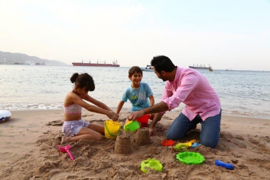 Family Having Fun By The Beach