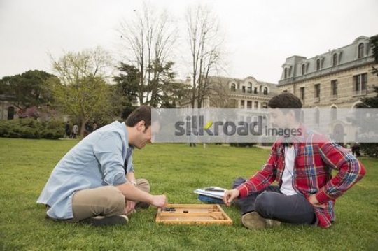 Men sitting on the grass talking|