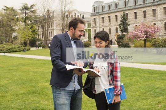University Student talking to the professor on campus|