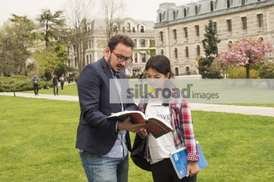 Studen talking to the professor on campus|
