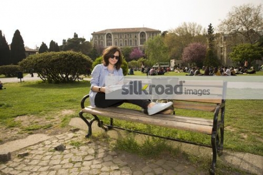 Student sitting on the bench reading a book|