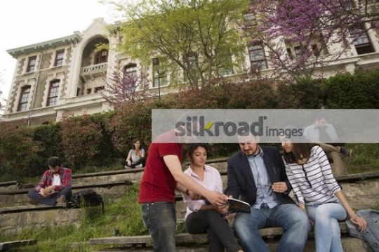 Students talking to the professor on campus|