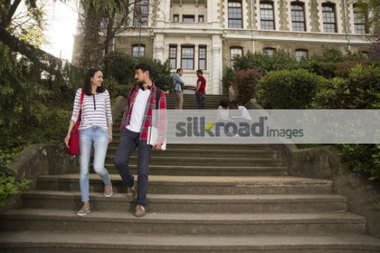 Man and woman walking down the stairs talking|