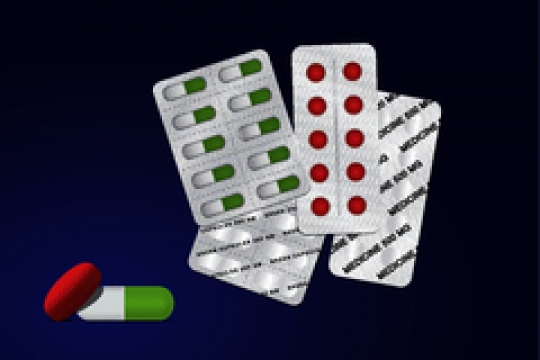 capsules and pills packed in blisters on blue background
