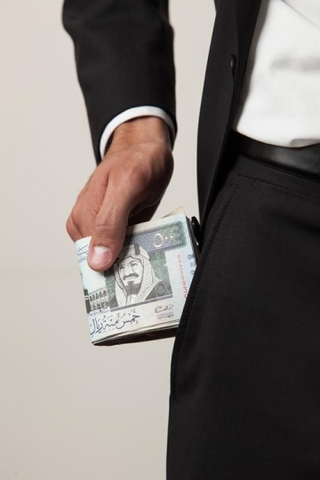 businessman putting money in his trouser pocket