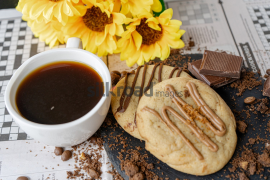 Cup of Coffee and Chocolate on Newspaper Games Page