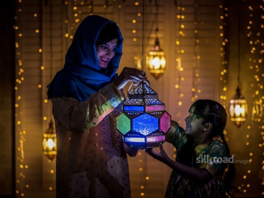 Mother and daughter holding lantern|-