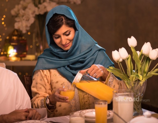 -|Mother pouring orange juice