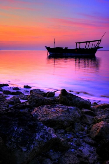 colorful sunset scene with a boat in the sea