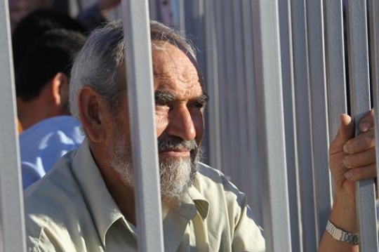 prisoner man looking from behind the bars