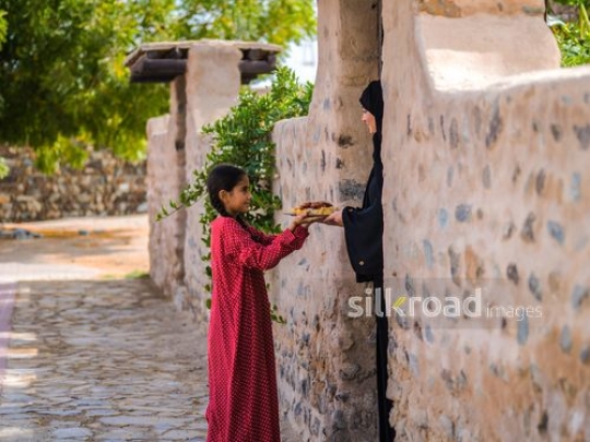Little girl giving plate to neighbor|-