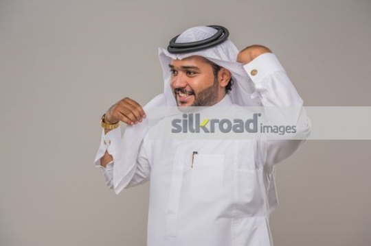 Middle Eastern man fixing his kandoura|