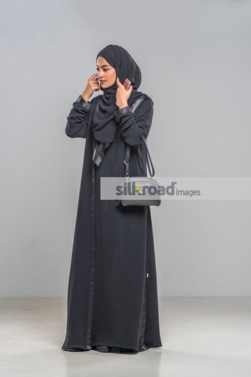 Middle Eastern Businesswoman fixing abaya|