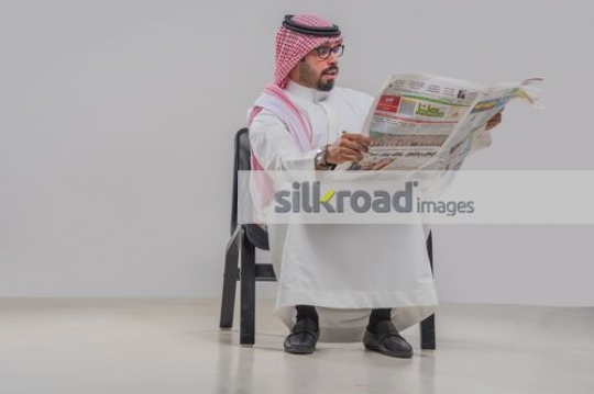 Middle Eastern man reading the newspaper