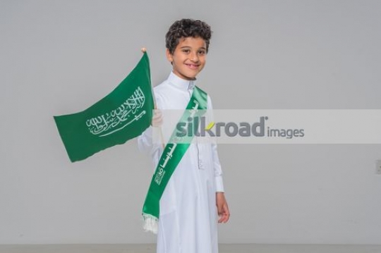 Young Middle Eastern boy carrying the Flag|