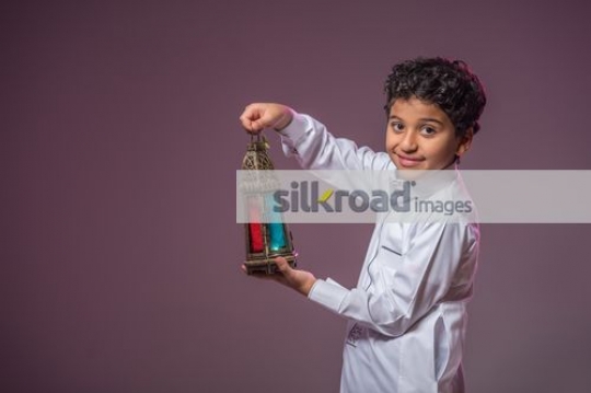 Middle Eastern boy smiling carrying the Ramadan Lantern|