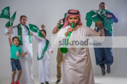 Group of Middle Eastern men and young kids celebrating|