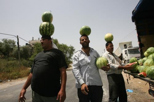 men holding watermelon on their head