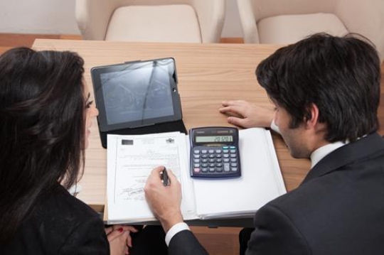 two colleagues discussing financial calculations at the workplace
