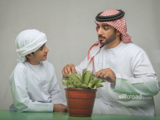Boy learning from his father about plants