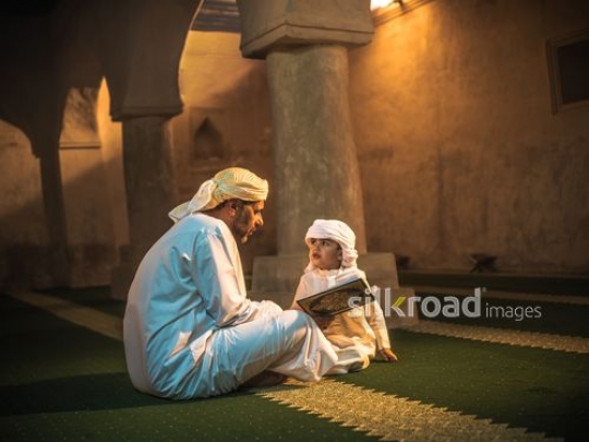 Old man reading qur'an with kid at the mosque|-
