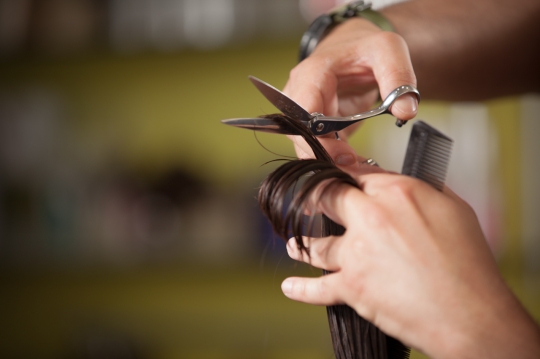 Hairstylist cutting hair|