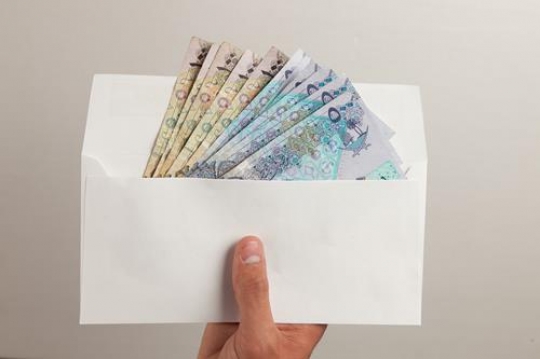 man hands holding an envelope with qatari riyal