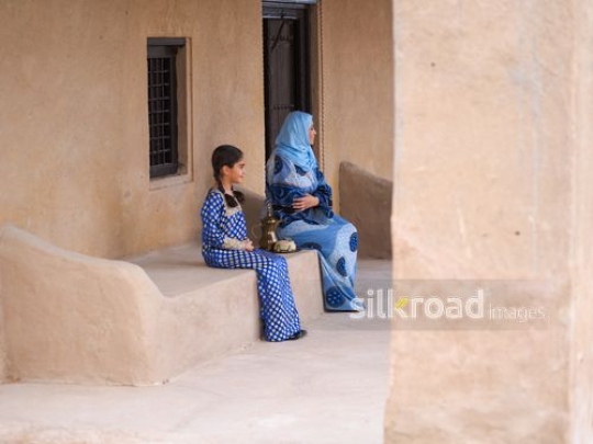 Mom and daughter sitting outside|-