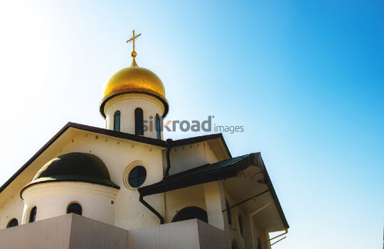 Golden Dome and Cross of Madaba Church with Blue Sky