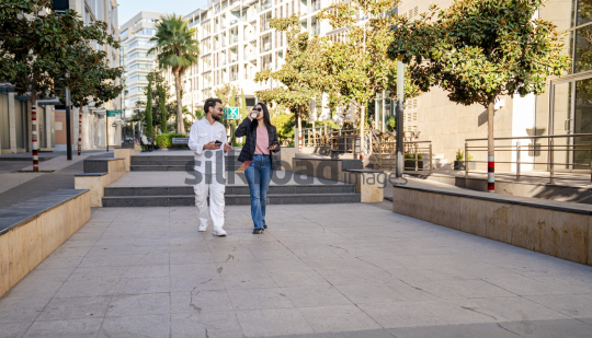 Professional Man and Woman Smiling with Coffee in Al Abdali Boulevard