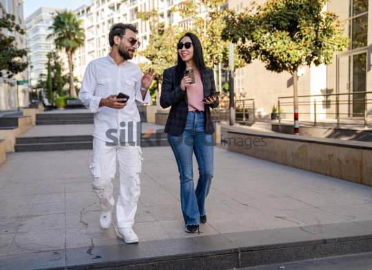 Professional Man and Woman Smiling with Coffee in Al Abdali Boulevard