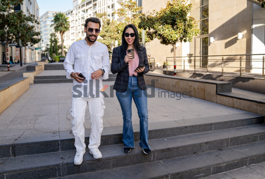 Professional Man and Woman Smiling with Coffee in Al Abdali Boulevard