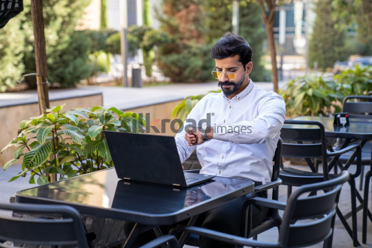 Professional Man Checking Watch for Meeting Time While Preparing for Zoom Call